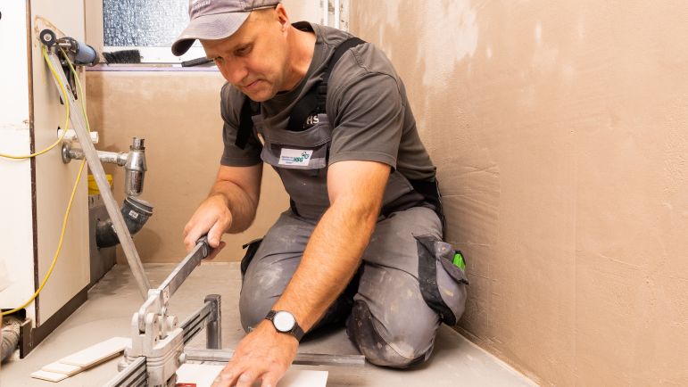 Ein Mitarbeiter der HSG schneidet Fliesen in ihre passende Form