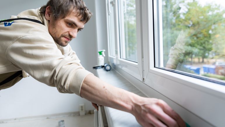 Mitarbeiter dichtet die Fensterfuge ab