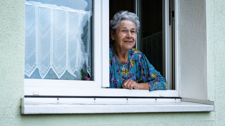 Frau schaut aus Fenster
